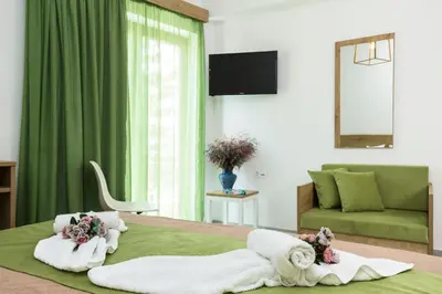 a bedroom with a bed with towels and a couch at Castell Hotel in Kissamos