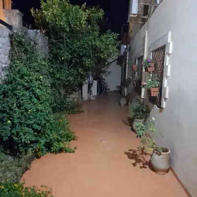 an alley filled with water at night with potted plants at Nikos Studio in Kalyves