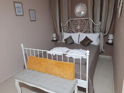 a white bed with a bench in a bedroom at Nikos Studio in Kalyves