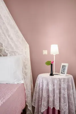 a bedroom with a table with a vase with a flower on it at Stone Built Private villa Emerald with pool, 30m to Beach & BBQ! in Ropanianá
