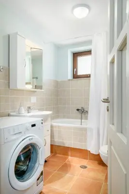a bathroom with a washing machine and a bath tub at Stone Built Private villa Emerald with pool, 30m to Beach & BBQ! in Ropanianá