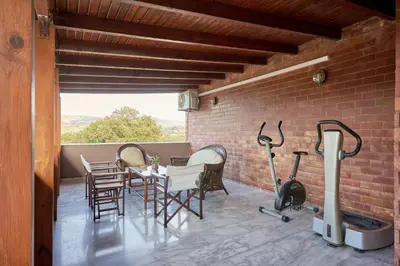 a patio with a table and chairs and a brick wall at Villa Felenia in Vryses