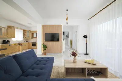 a living room with a blue couch and a table at Villa Felenia in Vryses