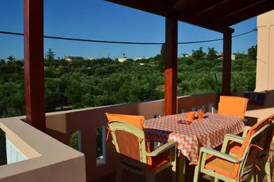 a table and chairs on a balcony with a view at Angellinas Apartments in Kato Daratso