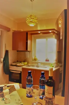 a kitchen with two bottles of wine and glasses on a table at Angellinas Apartments in Kato Daratso