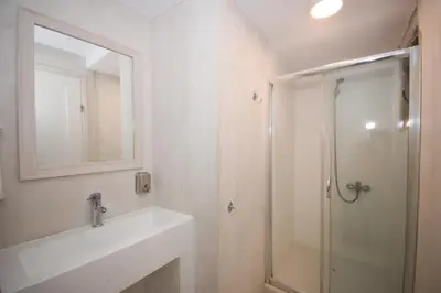 a bathroom with a shower and a sink and a mirror at Elia in Kavoúsion