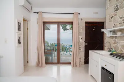 a kitchen with a door leading to a patio at Elia in Kavoúsion