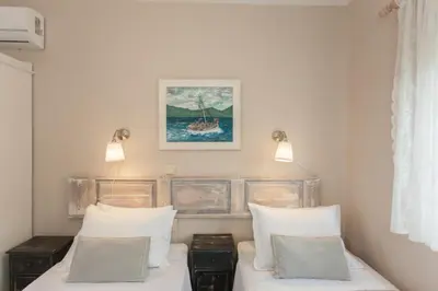 a bedroom with two beds and a painting on the wall at Aoria Villa By Hope Estate in Arménoi