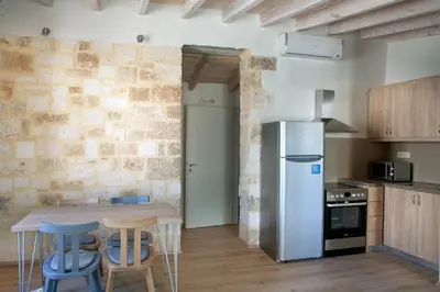 a kitchen with a table and chairs and a refrigerator at C&M Residence Chania Old Town in Chania Town