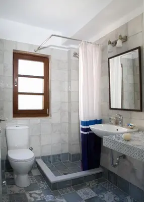 a bathroom with a toilet and a sink and a mirror at C&M Residence Chania Old Town in Chania Town