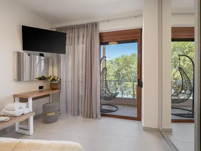 a living room with a door leading to a balcony at Elia Seaside in Chania Town