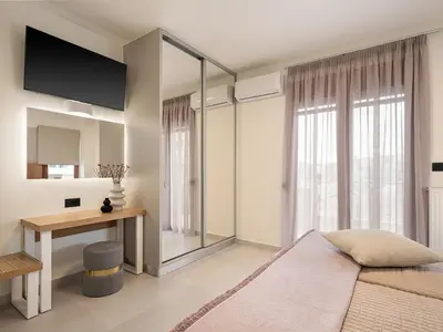 a bedroom with a bed and a desk and a window at Elia Seaside in Chania Town