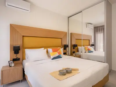 a bedroom with two beds and a large mirror at Elia Seaside in Chania Town