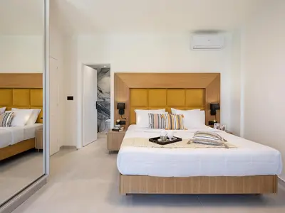 a bedroom with two beds and a mirror at Elia Seaside in Chania Town