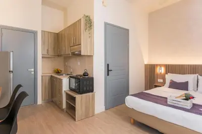 a bedroom with a bed and a small kitchen at Porto Orion Studios in Chania Town