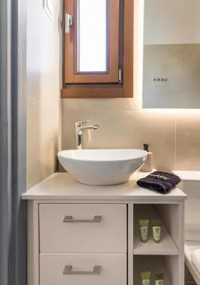 a bathroom with a white sink and a mirror at Porto Orion Studios in Chania Town