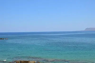 a large body of blue water with mountains in the background at Kalamaki Apartments in Kalamaki Chanion