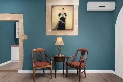 two chairs and a table with a lamp on a blue wall at Cretan Renaissance in Chania Town