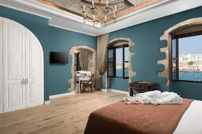 a bedroom with blue walls and a bed and a mirror at Cretan Renaissance in Chania Town