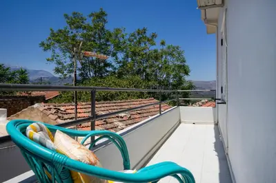a balcony with a chair and a view of the mountains at Irini House in Arménoi