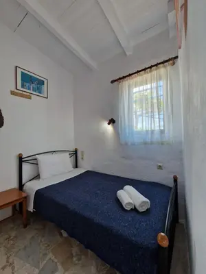 a bedroom with a bed with two white towels on it at Iliana's Bungalow in Arménoi