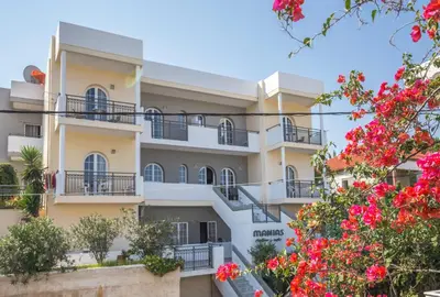 a building with flowers in front of it at Manias Hotel Apartments in Agia Marina Nea Kydonias