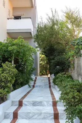 a staircase leading up to a building with trees at Manias Hotel Apartments in Agia Marina Nea Kydonias
