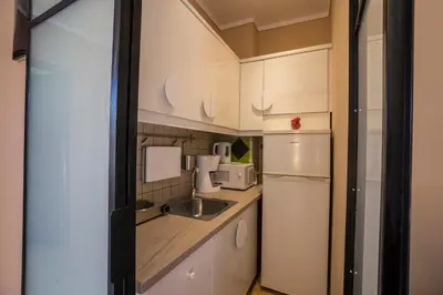 a kitchen with white cabinets and a sink and a refrigerator at Horizon Deluxe House in Chania Town