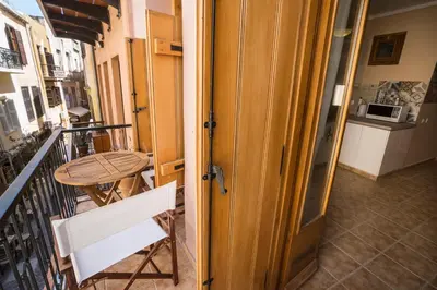 a balcony with a wooden door and a table at Horizon Deluxe House in Chania Town