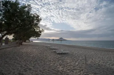 a beach with umbrellas and chairs on the sand at Electra Studios in Gerani Chanion