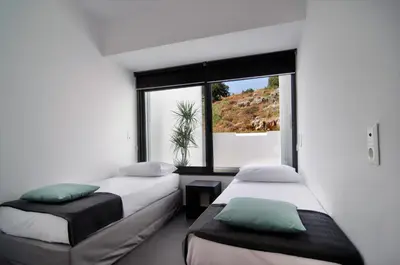two beds in a room with a large window at Seametry Luxury Living Apartments ADULTS ONLY in Souda