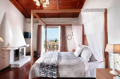 a bedroom with a canopy bed with a view at Villa Vanelia Mare in Kalamaki Chanion