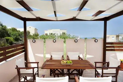 a patio with a wooden table and chairs at Villa Vanelia Mare in Kalamaki Chanion
