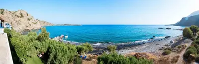 a view of a beach with people in the water at Taverna Akrogiali in Loutro