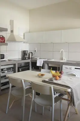 a kitchen with a table and chairs with a bowl of fruit on it at Christini Apartment in Chania Town