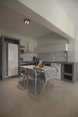 a white kitchen with a table and chairs in it at Christini Apartment in Chania Town