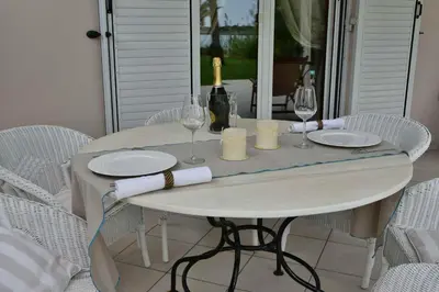 a white table with glasses and wine bottles on it at Ktima Grammeno Beachside Villa in Palaiochóra