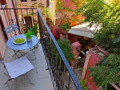 a table and chair on a balcony with plants at Odyssey Studios in Chania Town