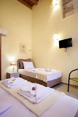 a hotel room with two beds and a flat screen tv at Odyssey Studios in Chania Town