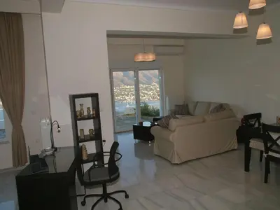 a living room with a couch and a table and chairs at Panoramic Seaview Holiday House in Souda