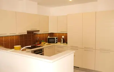 a large kitchen with white cabinets and a microwave at Panoramic Seaview Holiday House in Souda