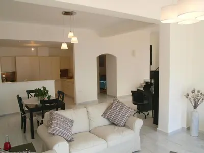 a living room with a white couch and a table at Panoramic Seaview Holiday House in Souda