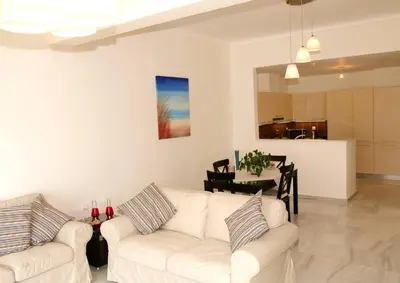 a living room with two white couches and a dining room at Panoramic Seaview Holiday House in Souda