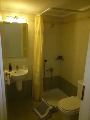 a bathroom with a shower and a toilet and a sink at Panoramic Seaview Holiday House in Souda
