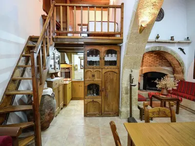 a large kitchen with a spiral staircase in a house at Villa in Crete with Vineyard Experience in Kalamítsion Alexándrou