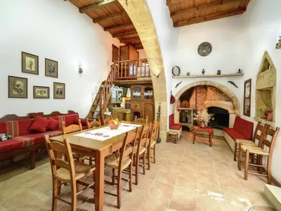 a living room with a wooden table and chairs at Villa in Crete with Vineyard Experience in Kalamítsion Alexándrou