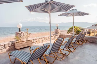 a group of chairs and umbrellas on the beach at Galini Beach Hotel in Kissamos