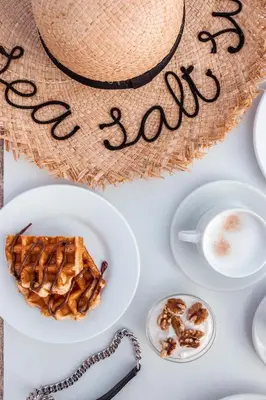 a table with a plate of waffles and a cup of coffee at Galini Beach Hotel in Kissamos