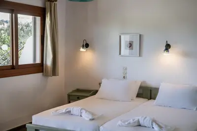 two beds in a room with a window at Androulakis Apartments in Gerani Chanion