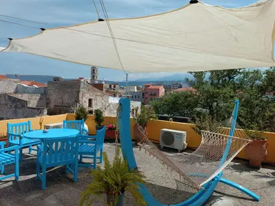 a patio with chairs and a table and a hammock at Imeros in Chania Town